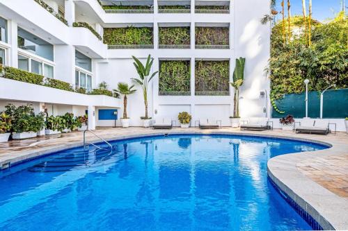 Modern hillside suite with balcony, city view, pools, gym & full kitchen